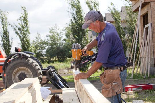 Tradesman Working On Framing For New Home Construction; St. Albert, Alberta, Canada