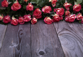beautiful roses lie on the wooden table front view