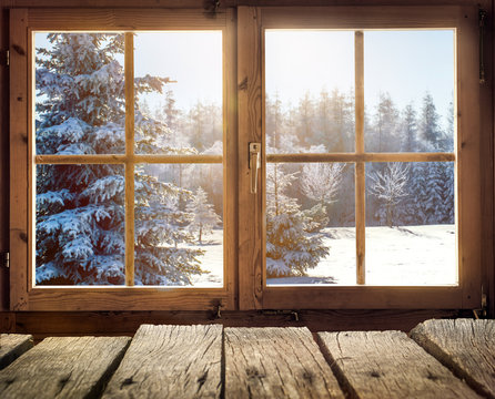 Blick aus dem Fenster einer Holzhütte im Winter 