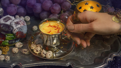 Female hands with oriental jewelery Pouring Tea into Cup. Tradit - Powered by Adobe