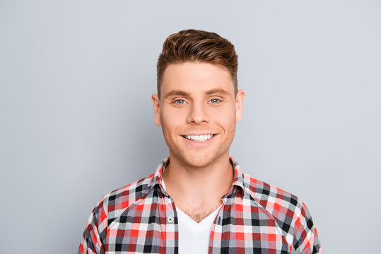 Portrait of handsome young man with beaming smile on gray backgr