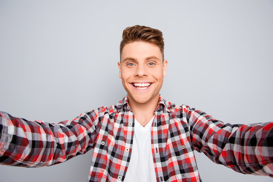 Happy young guy with beaming smile making selfie