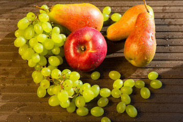 Grapes, pears and apples on a rustic wooden background