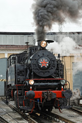 Fototapeta na wymiar Old steam soviet locomotive. Low key photo. Vintage style. Red star and lettering USSR.
