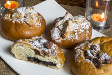 kompozycja z kołaczykiem drożdżowym makiem serem i rodzynkami na białym talerzyku i drewnianymi elementami, yeast dough with poppy seeds