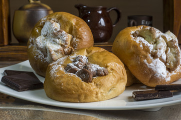 kompozycja z kołaczykiem drożdżowym makiem serem i rodzynkami na białym talerzyku i drewnianymi elementami, yeast dough with poppy seeds