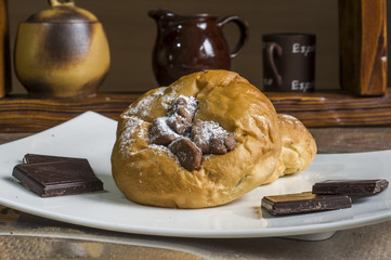 kompozycja z kołaczykiem drożdżowym makiem serem i rodzynkami na białym talerzyku i drewnianymi elementami, yeast dough with poppy seeds