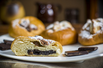 kompozycja z kołaczykiem drożdżowym makiem serem i rodzynkami na białym talerzyku i drewnianymi elementami, yeast dough with poppy seeds