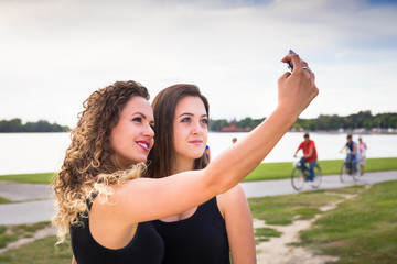 Two beautiful girls making selfie in summer