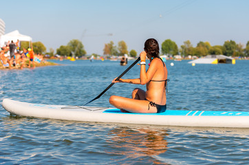 Young atractive and active woman on the paddleboard on the water surface, Nove Mlyny, South Moravia, Czech Republic