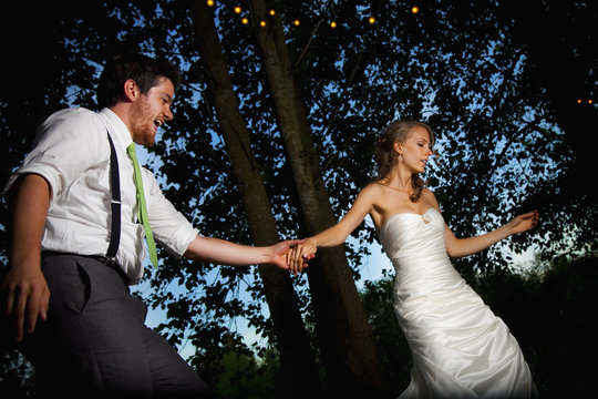 A Bride And Groom Dancing At Dusk On An Illuminated Dance Floor; Vancouver, British Columbia, Canada