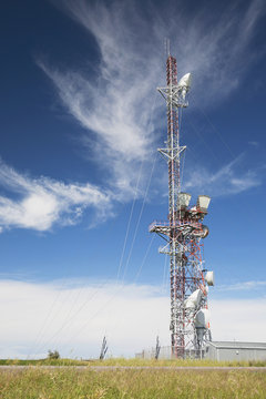 Telecommunications Tower In A Field With Blue Sky And Clouds; Alberta, Canada