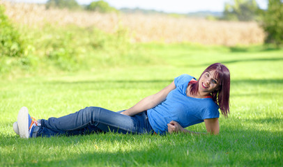 beautiful young woman in jeans lying on the grass