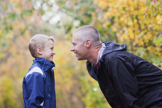 Father And Son Talking And Laughing On A Path In A Park; Edmonton, Alberta, Canada
