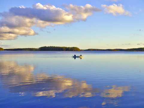 Rowing boat on beautiful calm lake with blue sky. Outdoor poster.