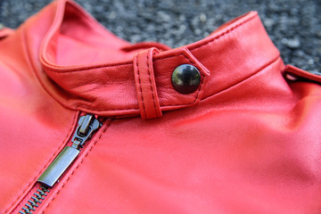 red leather woman jacket laying on asphalt. detail background