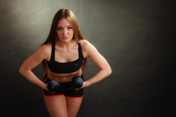 Fit woman exercising with dumbbells.