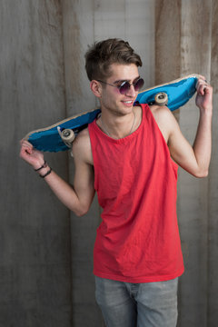 Portrait of young fashion guy with a skateboard