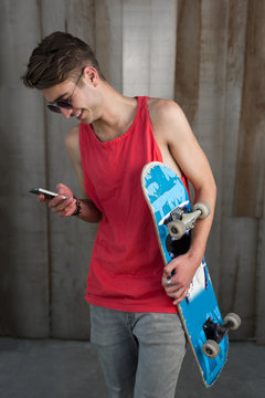 Teenage skater boy using smartphone wifi connected. Teenager por