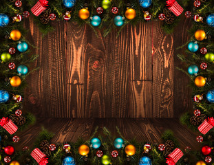 2017 Happy New Year seasonal background with real wood green pine, colorful Christmas baubles, gift boxe and other seasonal stuff over an old wooden aged background