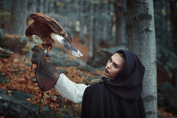Beautiful huntress with hawk in a forest © captblack76