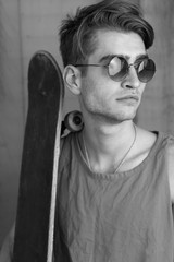 Portrait of young fashion guy with a skateboard