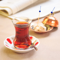 Cup of turkish tea with locum on oriental plate. Concept of turk