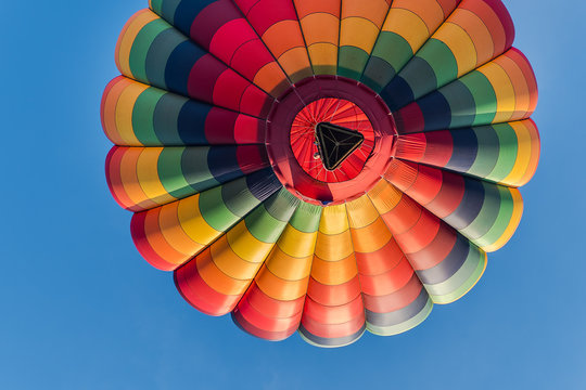 This is a photo of a beautiful hot air balloon slowly sailing through a calm blue sky.
