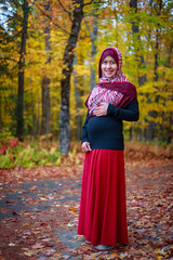 A pregnant muslim woman with natural background during autumn season