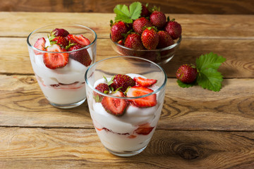 Layered dessert with cream, strawberry and ripe berries