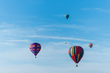 This is a photo of a beautiful hot air balloon slowly sailing through a calm blue sky.