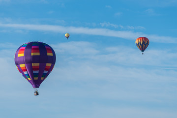 This is a photo of a beautiful hot air balloon slowly sailing through a calm blue sky.