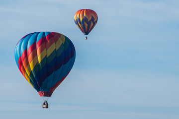 This is a photo of a beautiful hot air balloon slowly sailing through a calm blue sky.