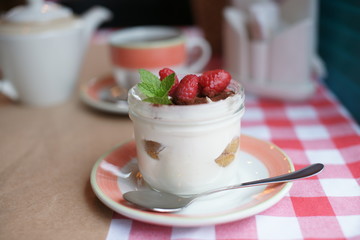 Tiramisu in a jar of glass on a table at a restaurant. 