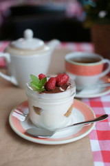 Tiramisu in a jar of glass on a table at a restaurant. 
