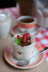 Tiramisu in a jar of glass on a table at a restaurant. 