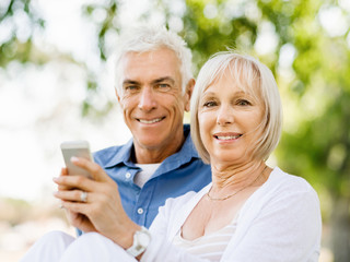 Happy senior couple looking at smartphone