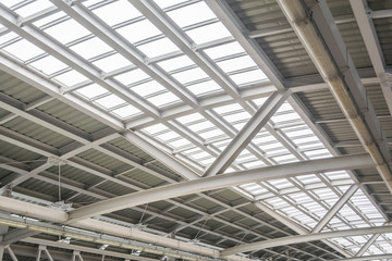 Gray and white metal roof structure in sunny day.