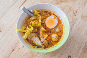 Spicy Thai Tomyum noodle with pork, vegetable, egg and balls.