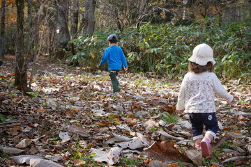 Fototapeta premium Young children running in forest in autumn