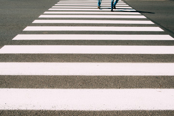 Crossroad with walking people background. Pedestrian zebra on asphalt close-up photo. City street,...