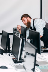 Repairman fixing computer monitor in office. Programmer fixing Screen for work in open space....