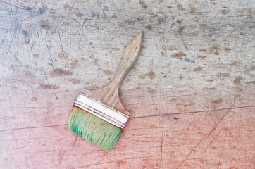 brush in green paint on a wooden background, vintage toning