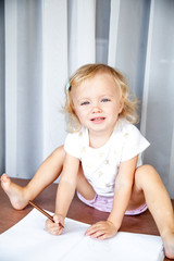 Naklejka premium Little girl drawing at home