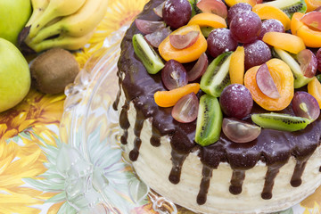 Tasty cake decorated with chocolate glaze and fruits (half cake)