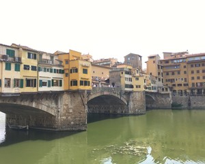 Fototapeta na wymiar LORENCE, ITALY - JULY 25, 2016 : view of the famous Ponte Vecchio in Florence during summer with boats on the river. 