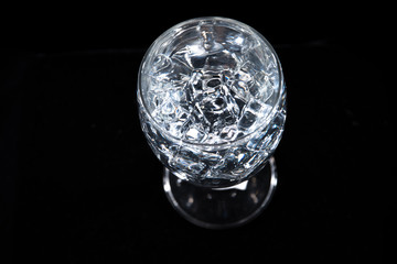 water with glass at black background