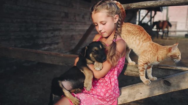 Curly Girl Caresses a Puppy and Cat at the Farm
