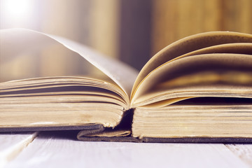 Open book on wood planks over abstract light background