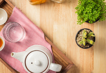 Hot tea in a teapot and placed on a wooden cactus healthy menu.
